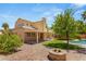 Expansive backyard with a swimming pool, covered patio, built in BBQ, fire pit, and ample green space at 215 Sunlight Peak St, Henderson, NV 89012