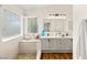 Bathroom with double sinks, modern lighting, wood floors and a shower over tub at 215 Sunlight Peak St, Henderson, NV 89012