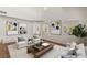 A virtually staged living room with neutral-toned furniture, decor, arched doorways, and wood flooring at 215 Sunlight Peak St, Henderson, NV 89012