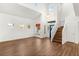 Bright living room with wood floors, staircase, and large window seat with a view of the front yard at 215 Sunlight Peak St, Henderson, NV 89012
