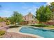 Backyard view featuring a sparkling pool, covered patio, built in BBQ, and lush green lawn at 215 Sunlight Peak St, Henderson, NV 89012