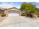 Two-car garage features a driveway and desert landscaping, complemented by mature trees at 2156 Eagle Sticks Dr, Henderson, NV 89012