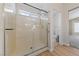 Walk-in shower with glass door, rain shower head, grab bar, and window at 2156 Eagle Sticks Dr, Henderson, NV 89012