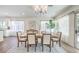 Bright dining room features a modern chandelier, wood table with seating for six, and large windows with sheer curtains at 2581 Terrytown Ave, Henderson, NV 89052