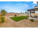 Expansive backyard featuring gravel landscaping, a grassy area, and a covered patio perfect for outdoor enjoyment at 2624 Stanhurst Ave, North Las Vegas, NV 89081