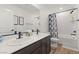 Elegant bathroom featuring double sinks, dark wood cabinets, modern fixtures, and a shower-tub combo at 2624 Stanhurst Ave, North Las Vegas, NV 89081