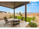 Inviting covered patio with modern outdoor furniture and a beautifully landscaped backyard at 2624 Stanhurst Ave, North Las Vegas, NV 89081