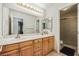 Bright bathroom with double sinks, wooden cabinets, a large mirror, and a separate shower room at 271 Sunshine Springs Ct, Henderson, NV 89014