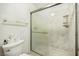 Close-up of a shower with a glass door, marble-look surround, toiletry shelf, and white toilet nearby at 271 Sunshine Springs Ct, Henderson, NV 89014