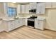 Modern kitchen featuring white cabinets, quartz countertops, stainless steel appliances and wood flooring at 3037 Holly Hill Ave, Las Vegas, NV 89104