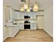Bright kitchen featuring white cabinets, stainless steel appliances, quartz counters and a modern chandelier at 3037 Holly Hill Ave, Las Vegas, NV 89104