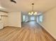 Open-concept living area featuring modern light fixture and wood flooring with natural light from the windows at 3037 Holly Hill Ave, Las Vegas, NV 89104