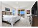 Comfortable bedroom with king bed, TV, and a balcony with views of the neighborhood at 3136 Mossfield Ave, Henderson, NV 89052