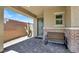 Welcoming front porch with brick accents, a bench, and a modern green door and desert landscaping at 3136 Mossfield Ave, Henderson, NV 89052