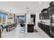 Open kitchen with large island, sleek black cabinetry, stainless steel appliances, and an adjacent dining area at 3136 Mossfield Ave, Henderson, NV 89052