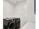 Modern laundry room featuring front loading washer and dryer and white countertops for folding and storing at 3136 Mossfield Ave, Henderson, NV 89052