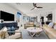 Bright living room with modern ceiling fan, sofas, stylish decor, and open layout to the kitchen at 3136 Mossfield Ave, Henderson, NV 89052