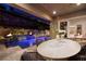 Beautiful outdoor dining area next to a luxurious pool with a waterfall feature at night at 33 Desert Juniper Ln, Henderson, NV 89011