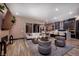 Open-concept living area featuring wood floors, modern furniture, and a seamless flow to the kitchen at 33 Desert Juniper Ln, Henderson, NV 89011