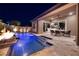 An outdoor patio with a fireplace that overlooks the pool area at 33 Desert Juniper Ln, Henderson, NV 89011