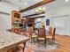 Charming dining area featuring a chandelier, wood beams, and view to the living area with stone fireplace at 330 Rancho Cir, Las Vegas, NV 89107