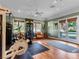 Bright gym with mirrored wall, hardwood floors, ceiling fan, and a glass doors leading to backyard at 330 Rancho Cir, Las Vegas, NV 89107