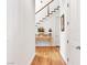 Bright hallway featuring hardwood floors, a staircase, and a decorative console table at 330 Rancho Cir, Las Vegas, NV 89107