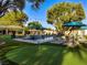 Serene backyard with a sparkling pool, lush greenery, and relaxing lounge areas at 330 Rancho Cir, Las Vegas, NV 89107