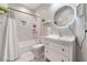 Bathroom with shower and tub combo featuring white vanity, chrome finishes, and round mirror at 3409 Judson Ave, North Las Vegas, NV 89030