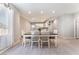 Modern dining area with a dark wood table, white chairs, and views into the open kitchen at 3409 Judson Ave, North Las Vegas, NV 89030