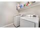 Efficient laundry room with modern washer and dryer units and a shelf with cleaning supplies at 3409 Judson Ave, North Las Vegas, NV 89030