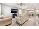 Open-concept living room with light wood floors, comfortable seating, and a view of the dining area at 3409 Judson Ave, North Las Vegas, NV 89030