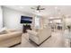 Open-concept living room with light wood floors, comfortable seating, and a view of the dining area at 3409 Judson Ave, North Las Vegas, NV 89030