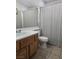 Bright bathroom featuring a wood vanity, tile floors, and shower with a stylish striped curtain at 3512 Trilogy Dr, Las Vegas, NV 89108