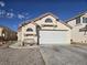 Home featuring a spacious two-car garage, desert landscaping, and a neutral color scheme at 3512 Trilogy Dr, Las Vegas, NV 89108