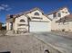 Home featuring a spacious two-car garage, desert landscaping, and a neutral color scheme at 3512 Trilogy Dr, Las Vegas, NV 89108