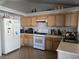 Functional kitchen with wood cabinets, tile floors, and white appliances for a classic look at 3512 Trilogy Dr, Las Vegas, NV 89108