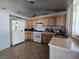 Functional kitchen with wood cabinets, tile floors, and white appliances for a classic look at 3512 Trilogy Dr, Las Vegas, NV 89108