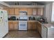 Functional kitchen with wood cabinets, tile floors, and white appliances for a classic look at 3512 Trilogy Dr, Las Vegas, NV 89108