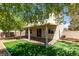 A view of the rear of the home with a covered patio and mature trees at 3809 Alpine Track Ave, North Las Vegas, NV 89032