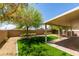 Well-maintained backyard with artificial turf, mature trees, and covered patio area at 3809 Alpine Track Ave, North Las Vegas, NV 89032