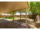 Backyard with covered patio, mature trees, and artificial turf at 3809 Alpine Track Ave, North Las Vegas, NV 89032