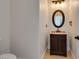 Powder room features a stylish vanity with marble countertop and an oval mirror at 3809 Alpine Track Ave, North Las Vegas, NV 89032