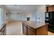 Open-concept kitchen flows into living area with island and stone countertops; modern appliances at 3809 Alpine Track Ave, North Las Vegas, NV 89032