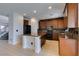 Modern kitchen with an island, stone countertops, black appliances, and wood cabinets at 3809 Alpine Track Ave, North Las Vegas, NV 89032