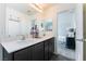 Bathroom with double sinks, dark cabinets, modern design, and view to bedroom at 4129 Chamisa Cove St, Las Vegas, NV 89115