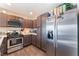 Modern kitchen with stainless steel appliances, dark brown cabinets, and ample counter space at 4129 Chamisa Cove St, Las Vegas, NV 89115