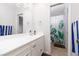 Bathroom with a white vanity, mirror, and a view into an adjacent shower at 4509 Paseo Del Ray Dr, Las Vegas, NV 89121