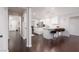 Open-concept kitchen leads to dining room, featuring white cabinets, island, and hardwood flooring at 4509 Paseo Del Ray Dr, Las Vegas, NV 89121