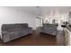 Large living room showcasing hardwood floors, gray sofas, and access to the kitchen at 4509 Paseo Del Ray Dr, Las Vegas, NV 89121